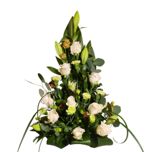 En blomsterarrangemang med vita rosor, gröna blad och slutna liljeknoppar i en triangulär form.